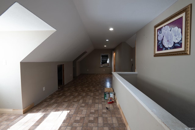 corridor with recessed lighting, vaulted ceiling, an upstairs landing, and baseboards