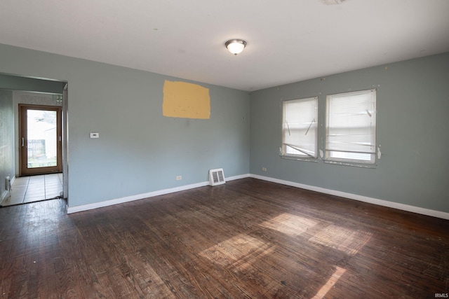 empty room featuring wood finished floors and baseboards