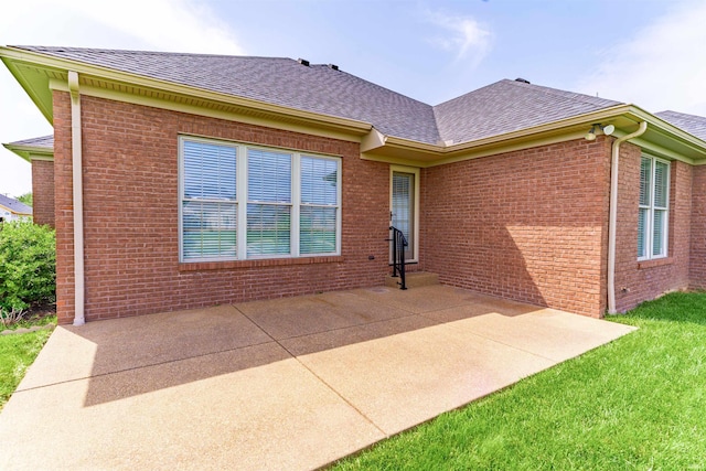 3121 Ralston Dr, Evansville, IN 47715 - back of property featuring a shingled roof, a patio area, brick siding, and a yard