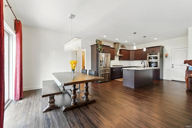 1263 E Legacy Ln, Winona Lake, IN 46590 - kitchen featuring wall chimney exhaust hood, stainless steel appliances, light countertops, dark wood-style flooring, and an island with sink