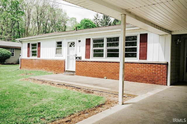 view of front of house featuring brick siding, board and batten siding, and a front lawn