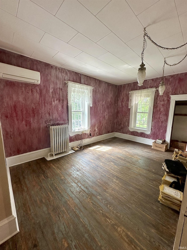 306 Wabash St, Berne, IN 46711 - unfurnished living room featuring radiator, a wall unit AC, hardwood / wood-style flooring, and plenty of natural light