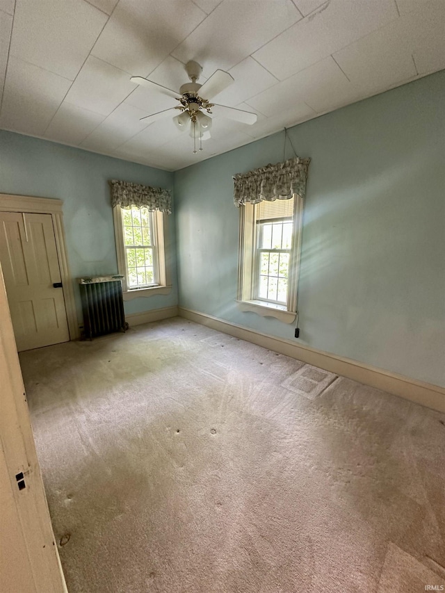306 Wabash St, Berne, IN 46711 - carpeted empty room with radiator, baseboards, and a ceiling fan