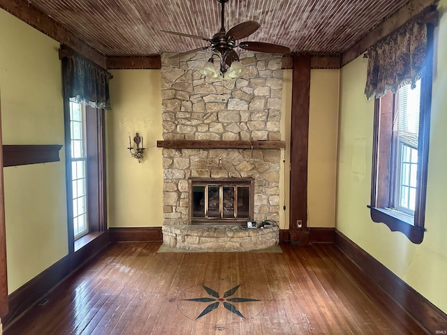 306 Wabash St, Berne, IN 46711 - unfurnished living room featuring ceiling fan, hardwood / wood-style floors, a stone fireplace, wood ceiling, and baseboards