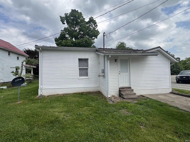 back of house with entry steps and a lawn