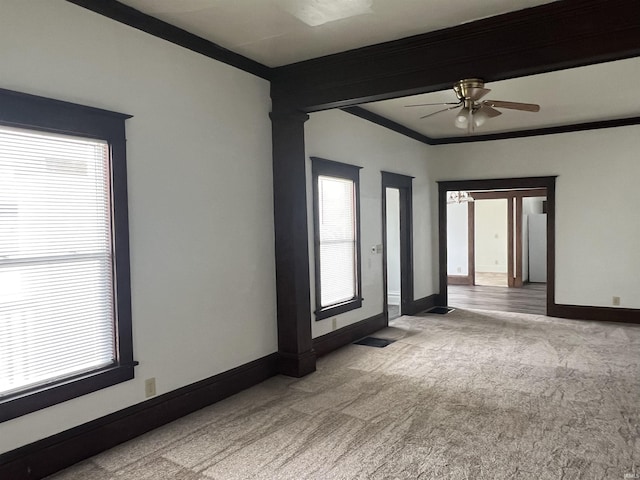 spare room with carpet, baseboards, ornamental molding, and ceiling fan