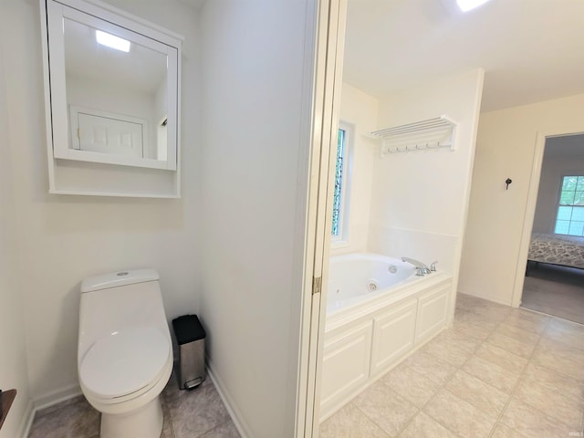 full bathroom featuring a jetted tub, toilet, and ensuite bathroom