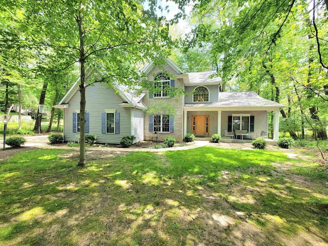 traditional home featuring covered porch and a front yard