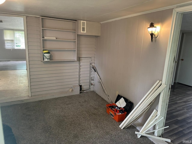 2711 S Villa Dr, Evansville, IN 47714 - empty room featuring crown molding, wood walls, and dark colored carpet