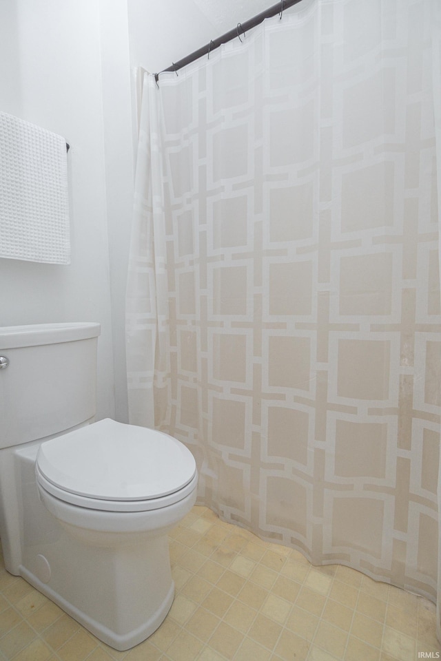 bathroom with toilet and a shower with curtain