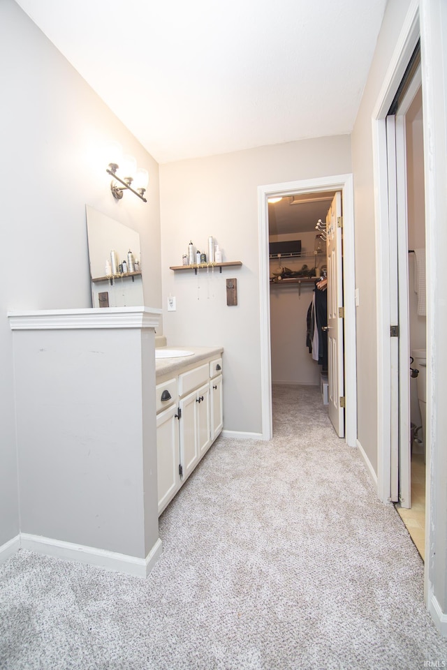 bathroom featuring vanity, carpet flooring, and baseboards