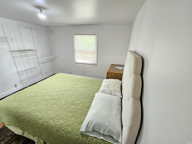 bedroom with wood finished floors and baseboards