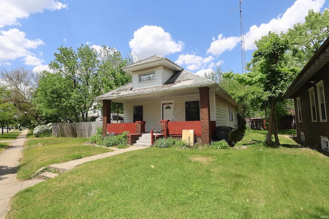bungalow featuring a porch, a front lawn, and brick siding