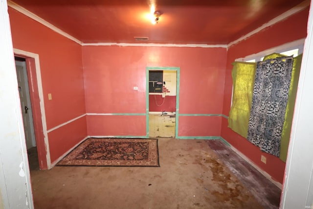 unfurnished room featuring crown molding, concrete floors, and baseboards