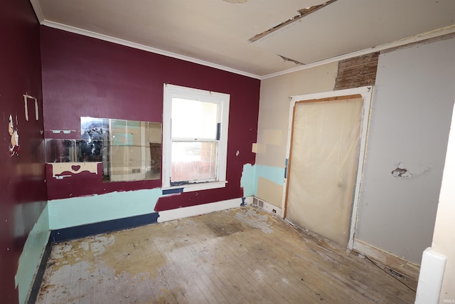 spare room featuring crown molding and hardwood / wood-style floors