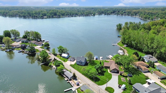 aerial view of residential area with a nearby body of water and a heavily wooded area