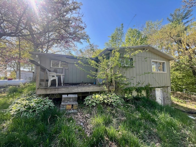 rear view of house featuring a wooden deck