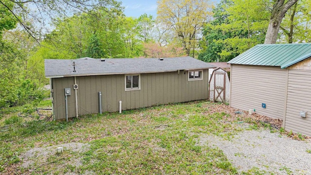 rear view of house featuring a shed and an outdoor structure