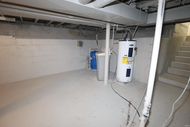 unfinished basement with electric water heater, a water softener system, and stairway