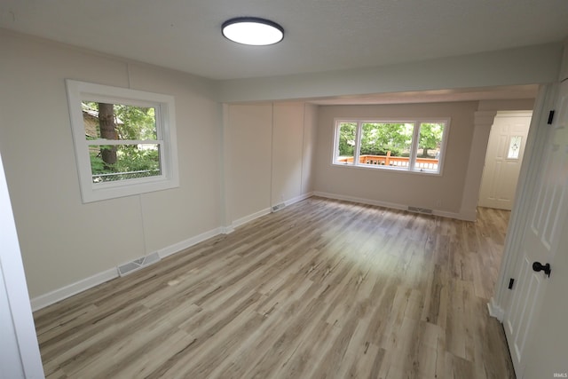 empty room featuring light wood finished floors and baseboards