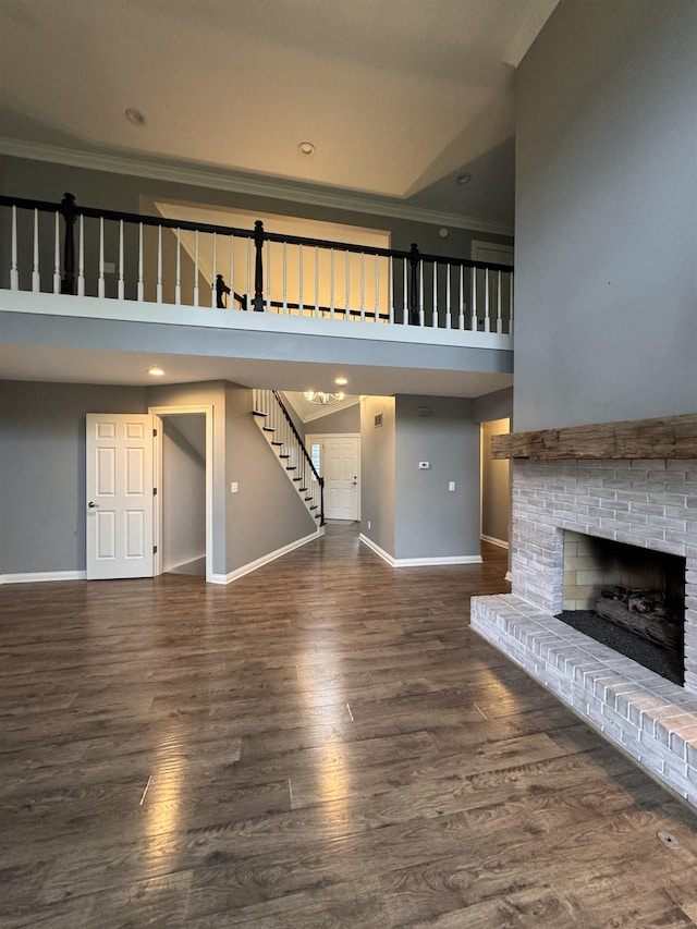 1953 S Troon Rd, Winona Lake, IN 46590 - unfurnished living room with crown molding, stairs, a fireplace, baseboards, and a towering ceiling