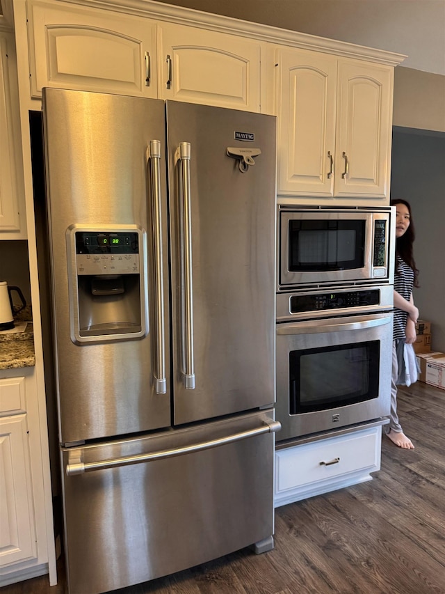 1953 S Troon Rd, Winona Lake, IN 46590 - kitchen featuring appliances with stainless steel finishes, dark wood finished floors, light stone countertops, and white cabinets