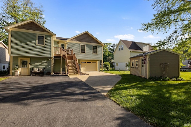 view of front facade with stairway, driveway, an attached garage, and a front lawn