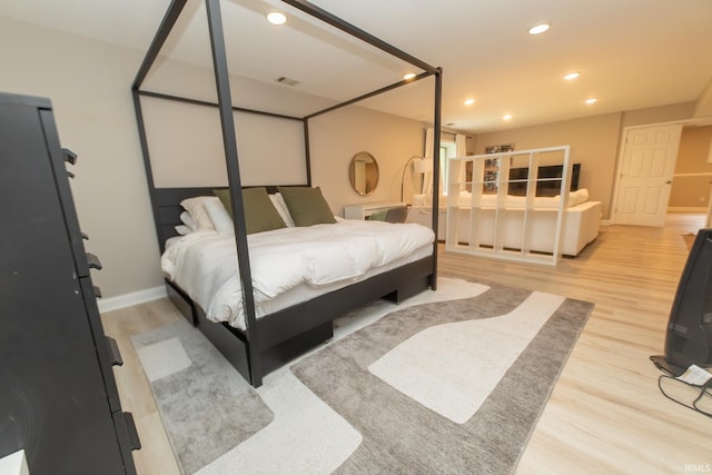 bedroom with wood finished floors, recessed lighting, and baseboards
