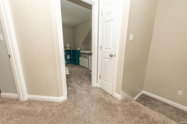 hallway featuring carpet floors and baseboards