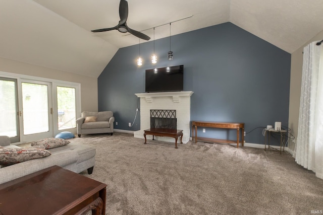 living area featuring vaulted ceiling, ceiling fan, baseboards, carpet floors, and a brick fireplace