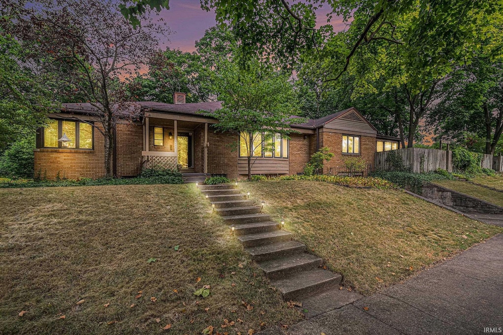 1402 E Colfax Ave, South Bend, IN 46617 - view of front of home with brick siding, a chimney, a porch, and stairs