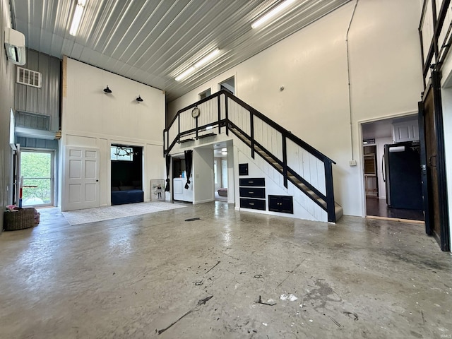 11475 Tedrow Ln, Shoals, IN 47581 - unfurnished living room featuring a high ceiling, stairs, and concrete flooring