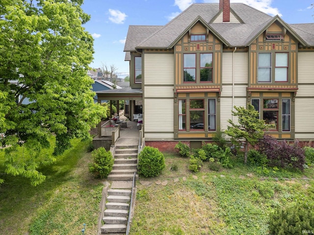 511 N 7th St, Lafayette, IN 47901 - victorian-style house featuring a chimney, a shingled roof, a front yard, and stairs