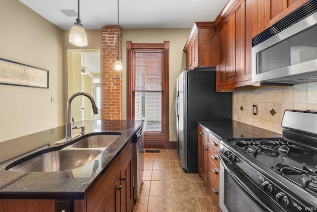 511 N 7th St, Lafayette, IN 47901 - kitchen featuring stainless steel appliances, backsplash, a sink, dark stone countertops, and pendant lighting