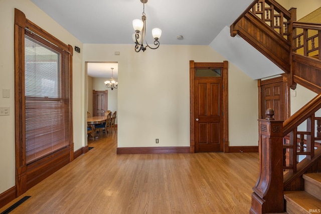 511 N 7th St, Lafayette, IN 47901 - unfurnished dining area featuring a chandelier, stairway, light wood-type flooring, and baseboards