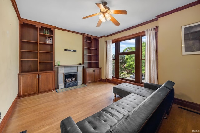 511 N 7th St, Lafayette, IN 47901 - living room with baseboards, a fireplace, light wood-style flooring, ceiling fan, and crown molding