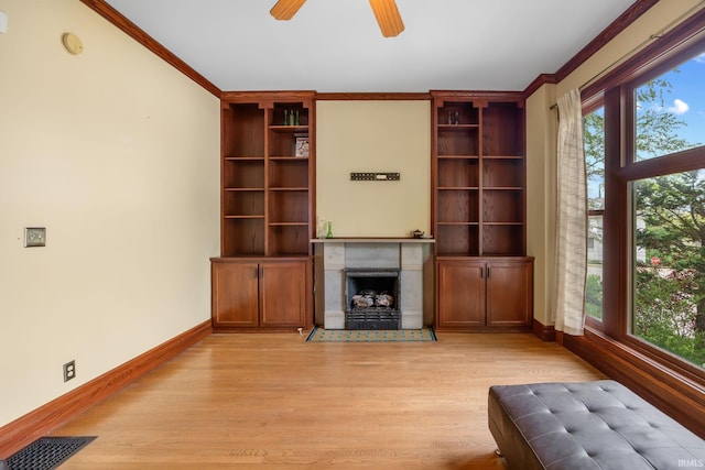 511 N 7th St, Lafayette, IN 47901 - unfurnished living room featuring light wood-style flooring, baseboards, crown molding, a ceiling fan, and a fireplace