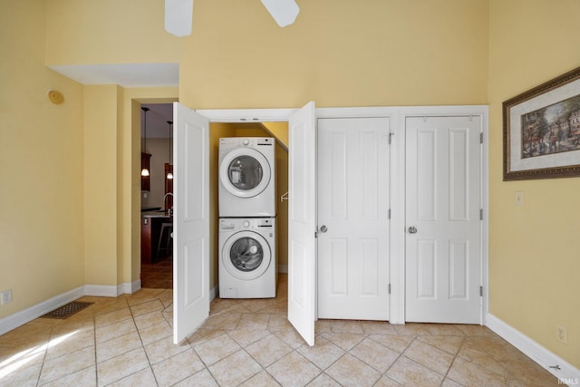 511 N 7th St, Lafayette, IN 47901 - clothes washing area featuring stacked washer and clothes dryer, ceiling fan, light tile patterned floors, and baseboards