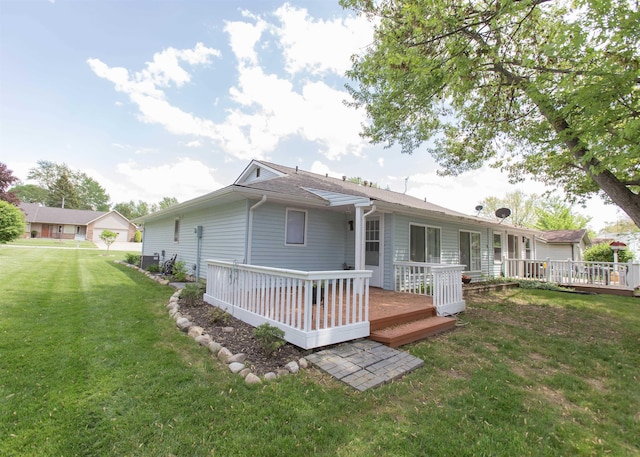 rear view of house featuring a deck and a yard