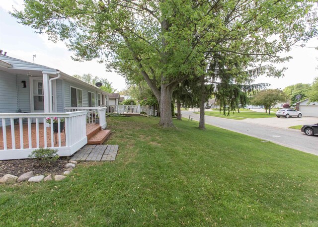 view of green lawn with a deck