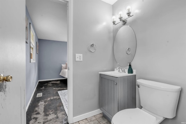 bathroom featuring toilet, baseboards, and vanity