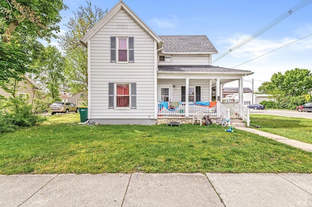 view of front of house featuring covered porch, roof with shingles, and a front yard