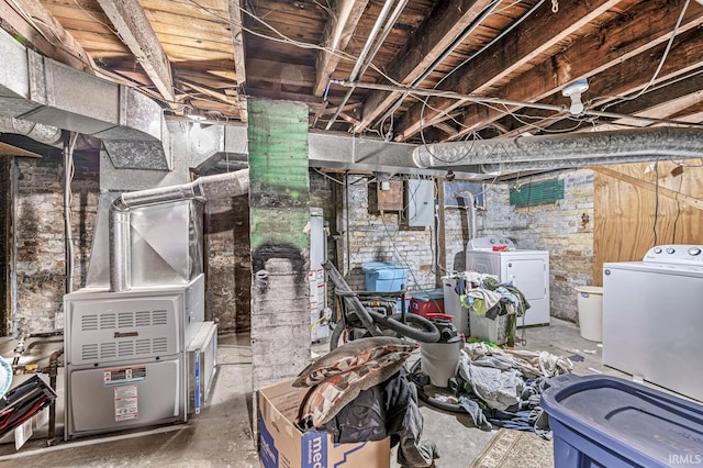 unfinished basement featuring separate washer and dryer, electric panel, and heating unit