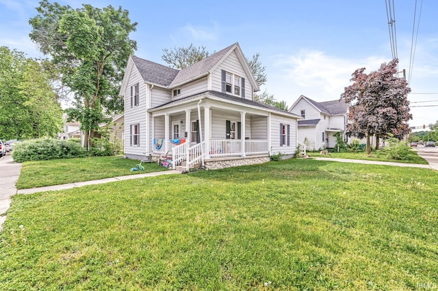 view of front of property with covered porch, a front lawn, and roof with shingles