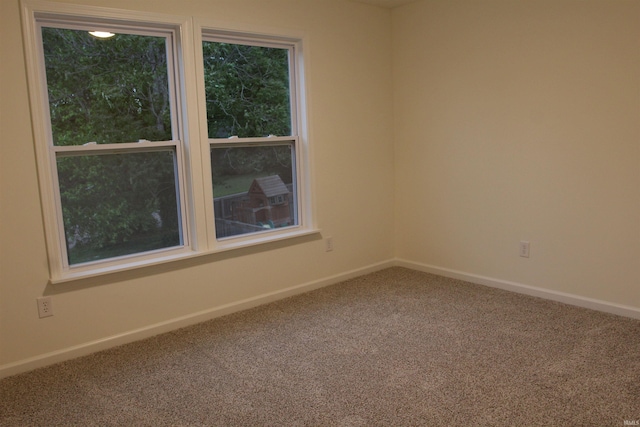 unfurnished room featuring carpet floors and baseboards