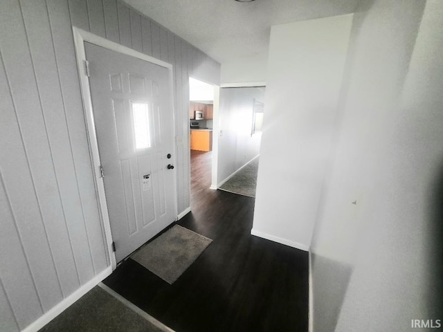 corridor with dark wood finished floors and baseboards