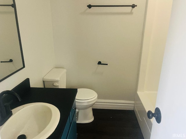 bathroom featuring baseboards, toilet, vanity, a tub to relax in, and a shower