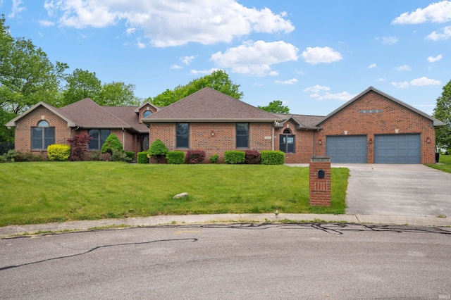 view of front of house featuring brick siding, driveway, a front yard, and a garage
