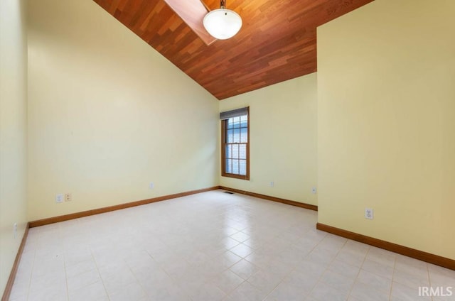 empty room featuring wood ceiling, lofted ceiling, and baseboards