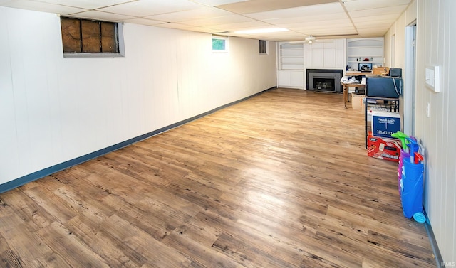6408 Washington Ave, Evansville, IN 47715 - basement with a fireplace, a drop ceiling, baseboards, and light wood-style floors
